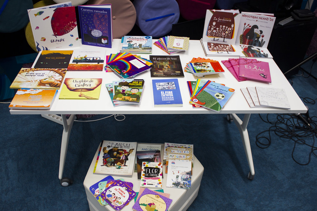 a variety of colourful books placed on top of a white plastic table for display.