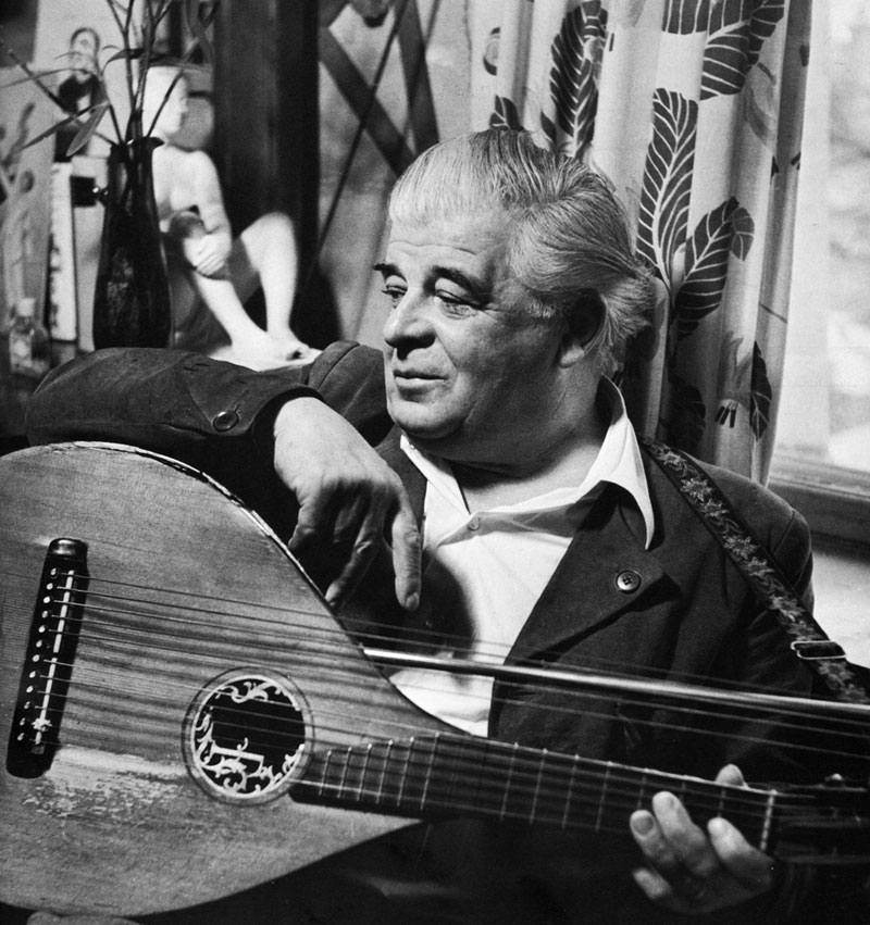 Black and white photo of Evert Taube with a string instrument.