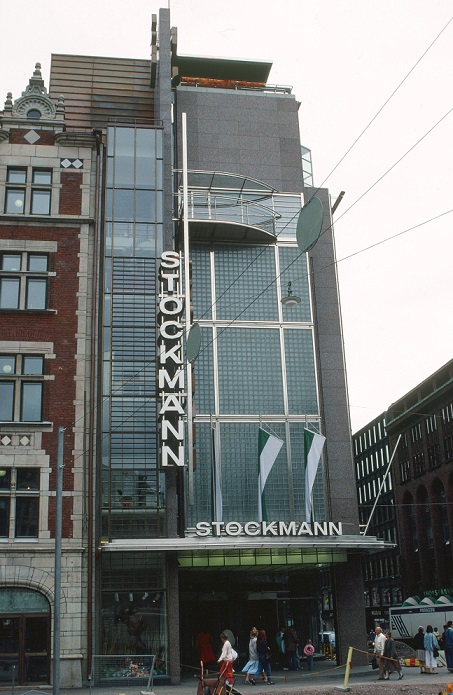 Tall grey-ish building with the letters 'STOCKMANN' vertically and also horisontally over the entrance.