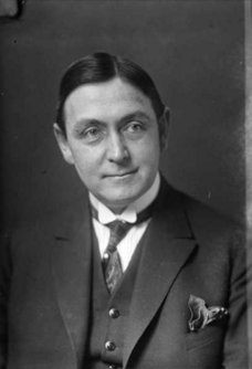 Black and white portrait of a man with dark hair in a suit