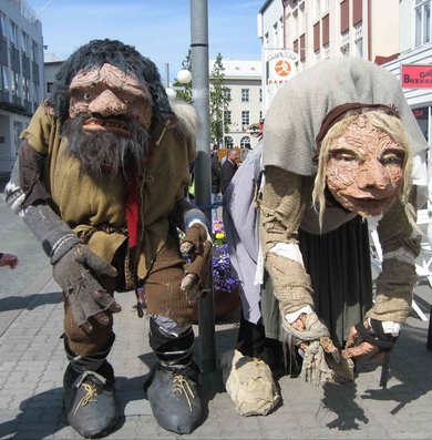 Two large human sized dolls walking on the streets