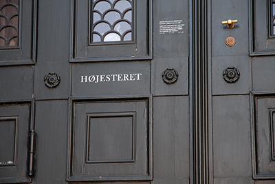 a door with a small sign on it saying 'HØJESTERET' which translates into 'The Surpreme Court' in Danish 