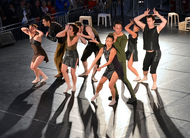 A play on stage with ballerinas wearing dark rough clothes