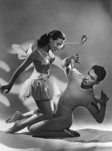 black and white picture of woman dancer with wings above a male dance crouching 