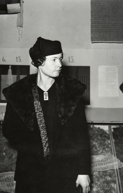 Black and white photo of young Sally Salminen in her formal attire: a big fur coat and an elegant hat.