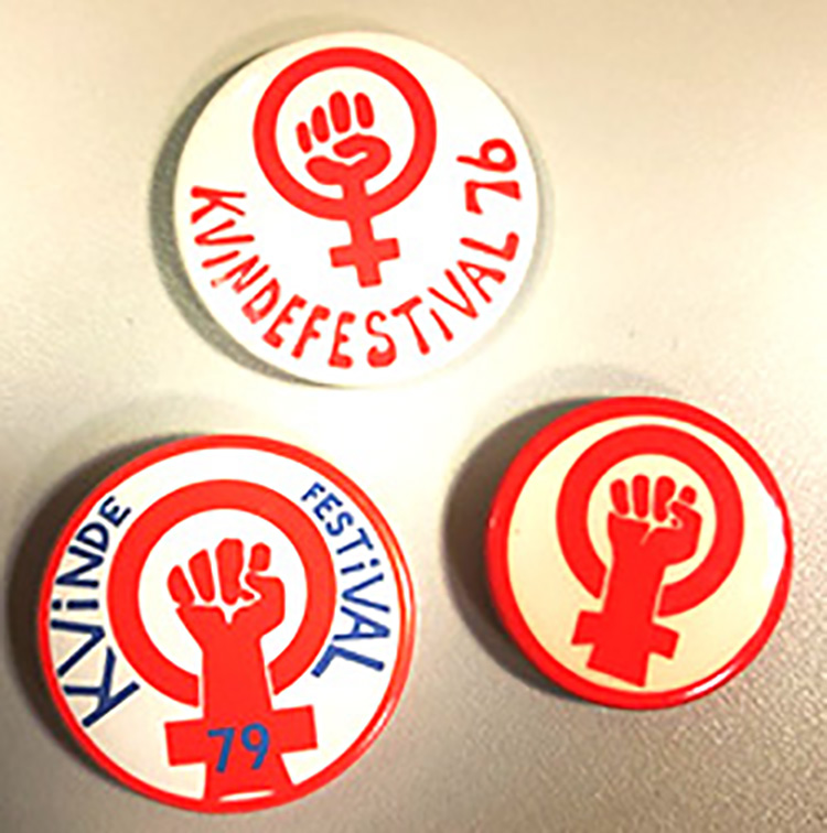 Three badges with a red symbol of a fist in combination with the symbol of woman gender on top