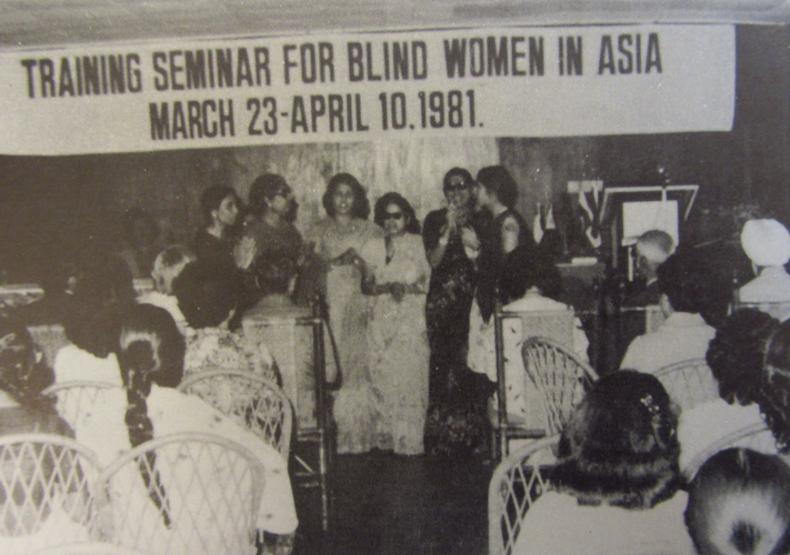 inside the training seminar for blind women. several women are sitting beside eachother in rows