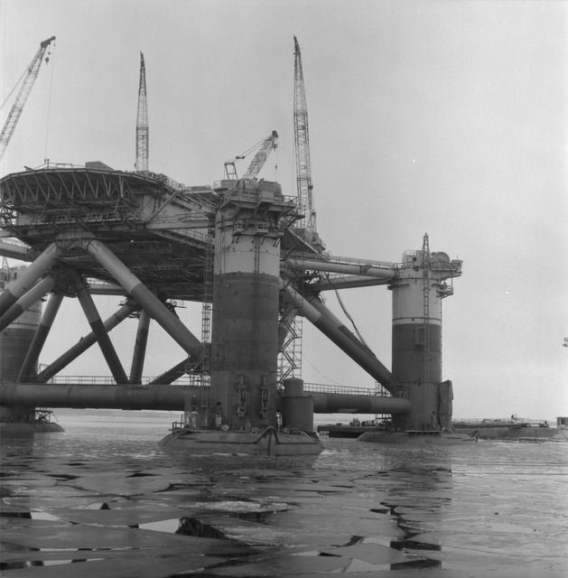 Black and white photo of an oil facility on the water