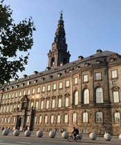 The Danish parliament "Christiansborg" viewed from a frog-eyed perspective with a blue sky in the background.