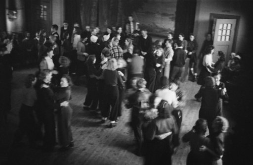 young people dancing together and having fun in a dark wide room.