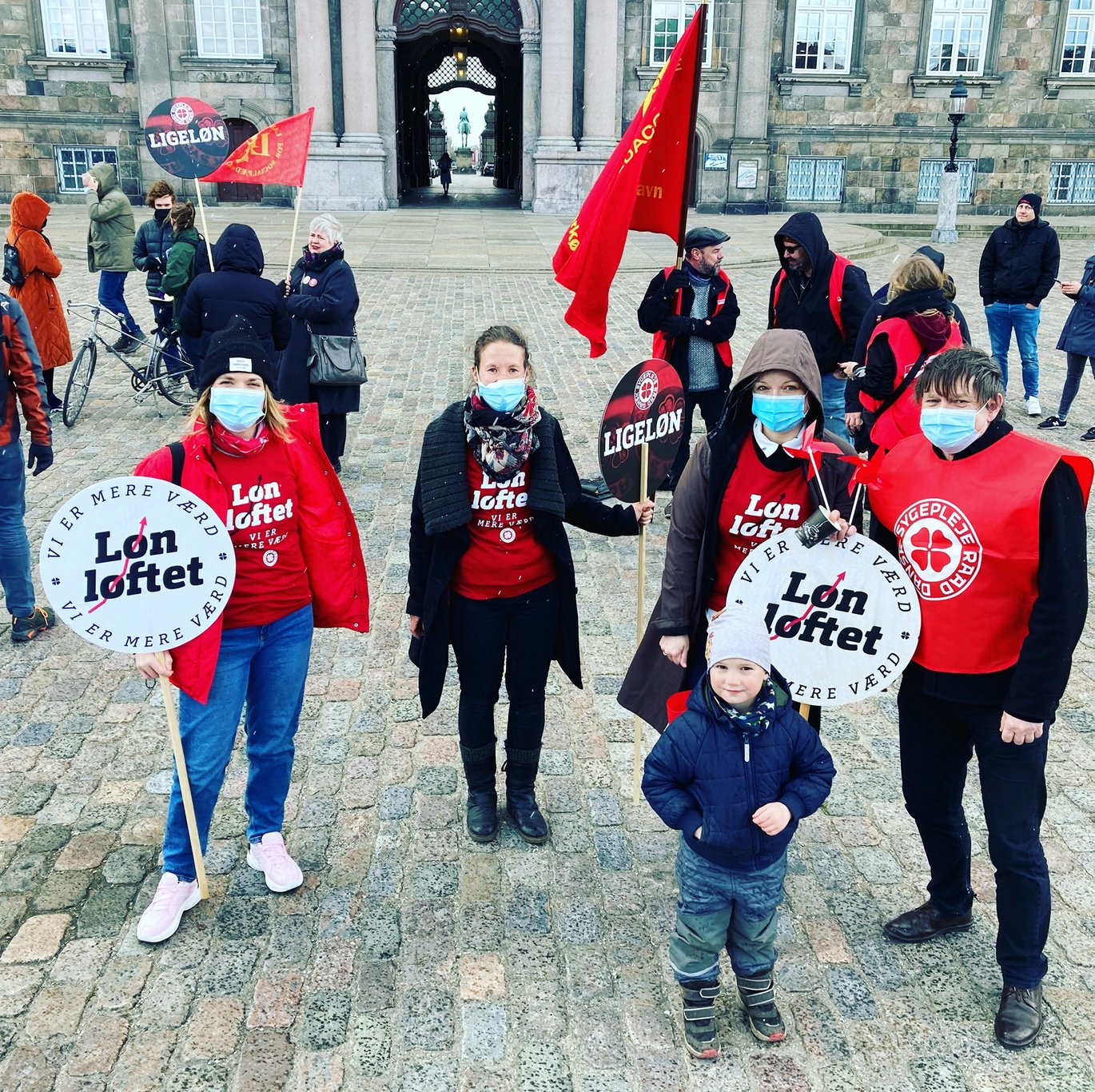 A group of people demonstrating in red clothes and with red banners.