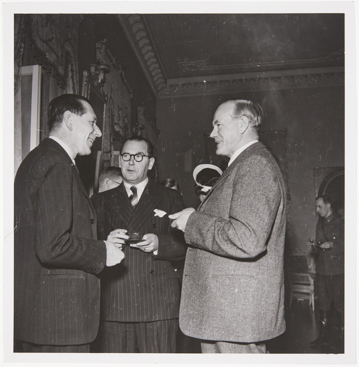 Three men in formal attire chatting 