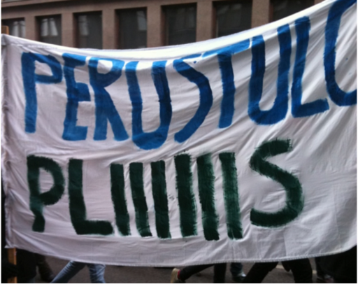 A demonstration poster with "Basic income for students pliiiiis" written on it.