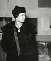Black and white photo of young Sally Salminen in her formal attire: a big fur coat and an elegant hat.