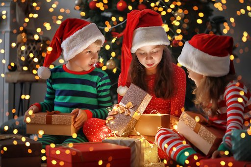 Children in Christmas hats looking at presents.