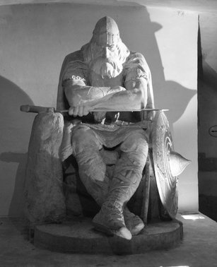 Large white statue of a man with long beard sitting on a throne