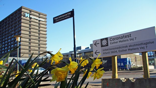Outside a hospital with focus on a sign showing the way for corona testing
