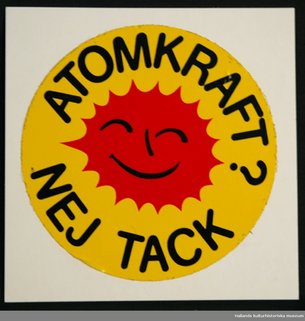 'Atomkraft Nej Tack' is written on a sticker with an emoji type face. The sticker is red and yellow and quite naive.