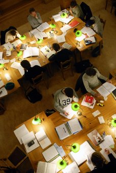 ariel shot of students studying in a library in soft light with lamps