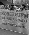 Black and white photo of several women holding a banner reading "vores hjem" (our home). The photo is from a demonstration against the so called 'ghetto list', Copenhagen September 2018.