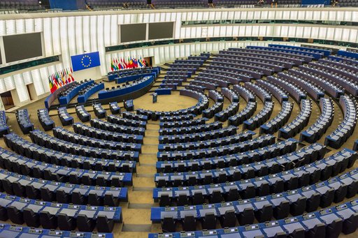 På billedet ses indersiden af Europa-Parlamentet i Strassburg. Rækker af sæder er placeret i en halvcirkel rundt om midten, hvor der er et talerstol til en taler.