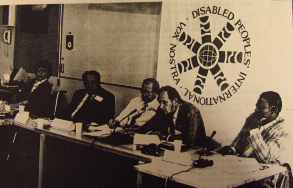 An oldfashioned, sepiacoloured photo of a meeting held in Stockholm, when DPI was founded. There are five men from different parts of the world; Sweden, the US, Canada and Zimbabwe.