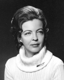 Black and white photo of a woman in her 30-40's looking to the right, wearing a white turtleneck