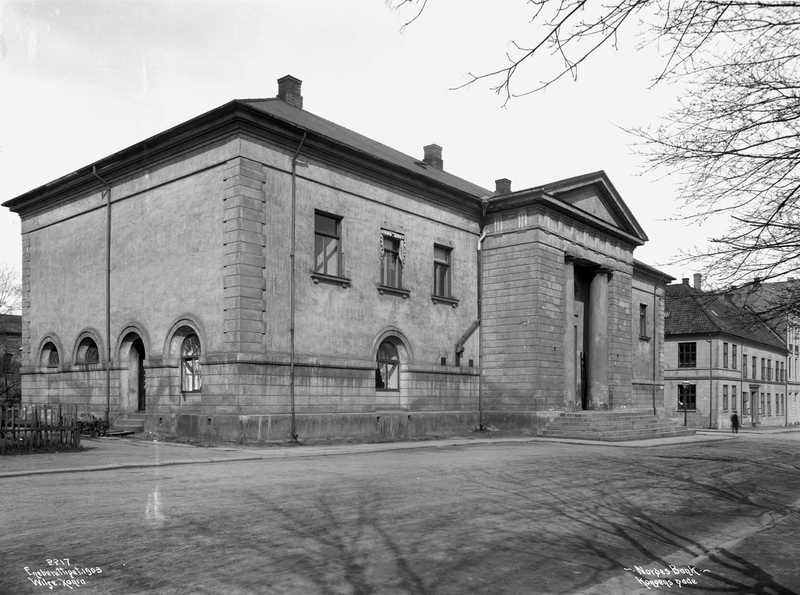 A black and white photograph of a large square building that is a bank.