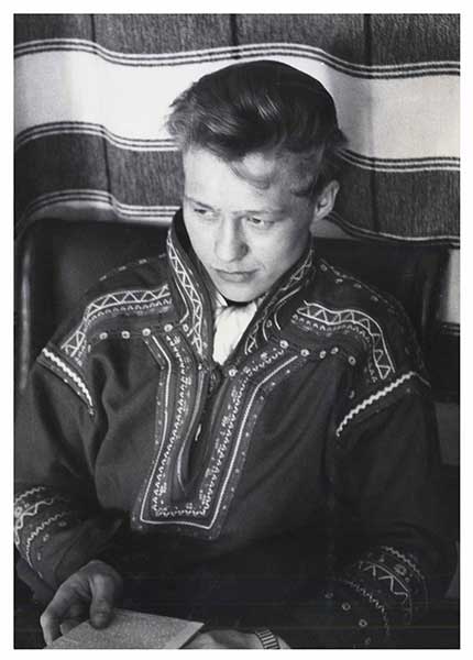 Black and white upper body shot of young man in casual Sami dress, looking away from the camera