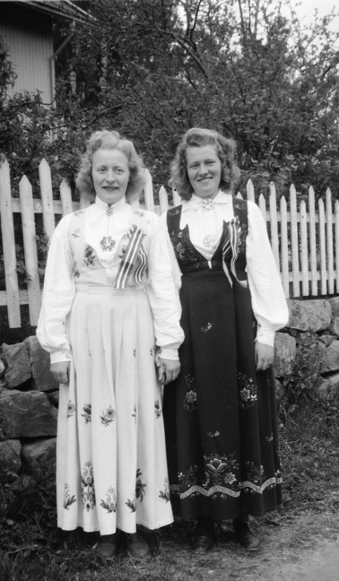 Two unknown women in the Norwegian national dress, the 'bunad' in 1930. The dresses are longsleeved and reach down to their ankles.