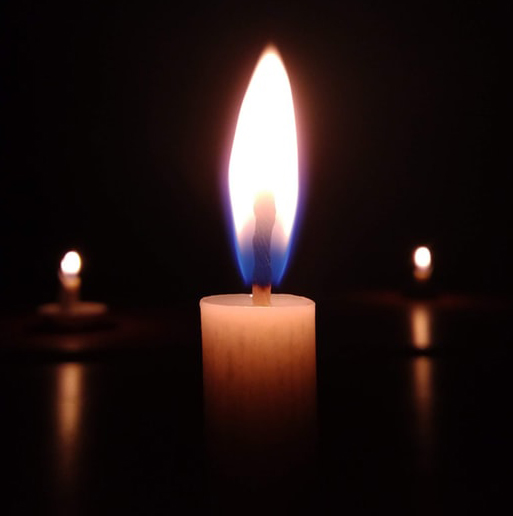 A lit candle in the dark