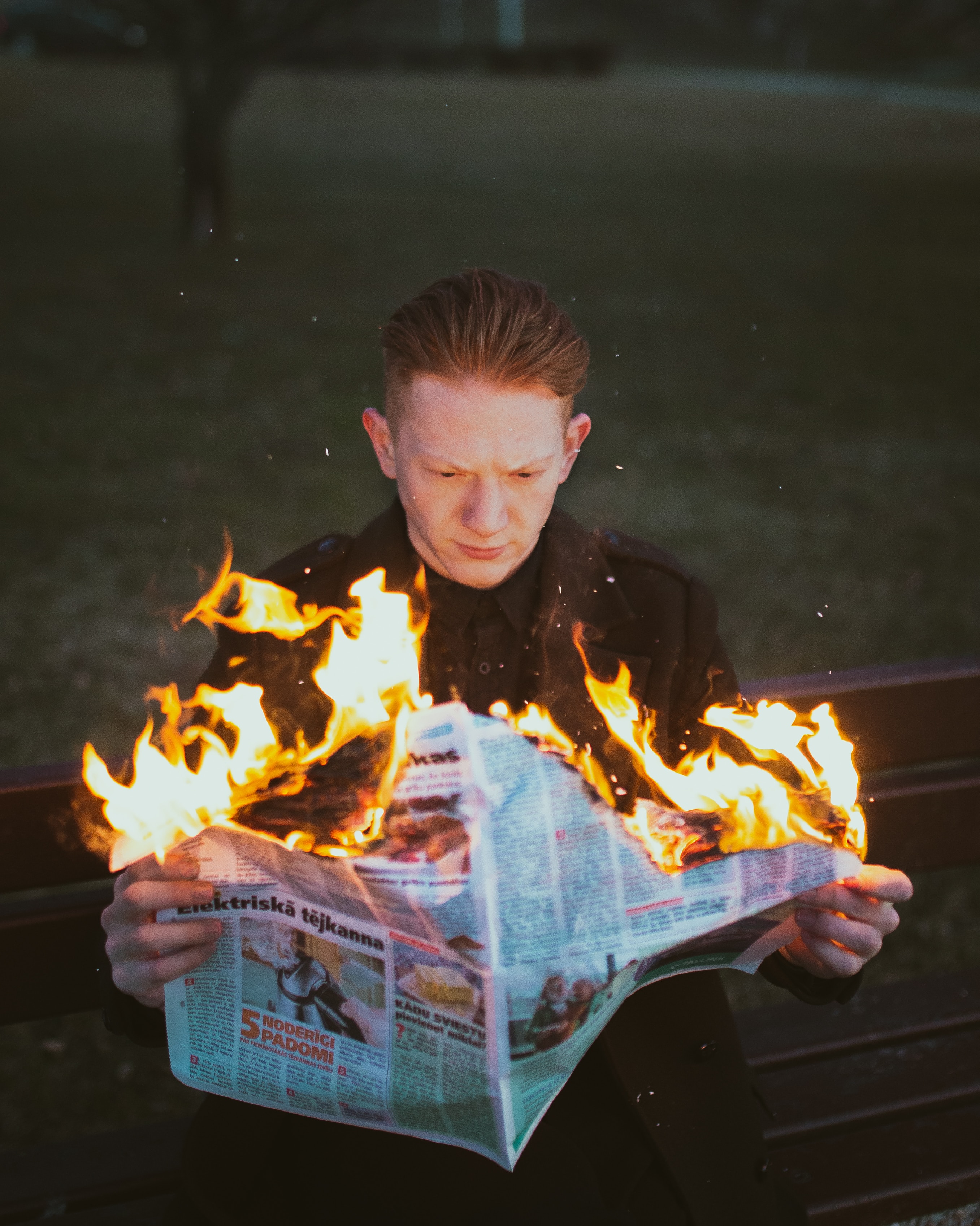 a young boy burning a newspaper