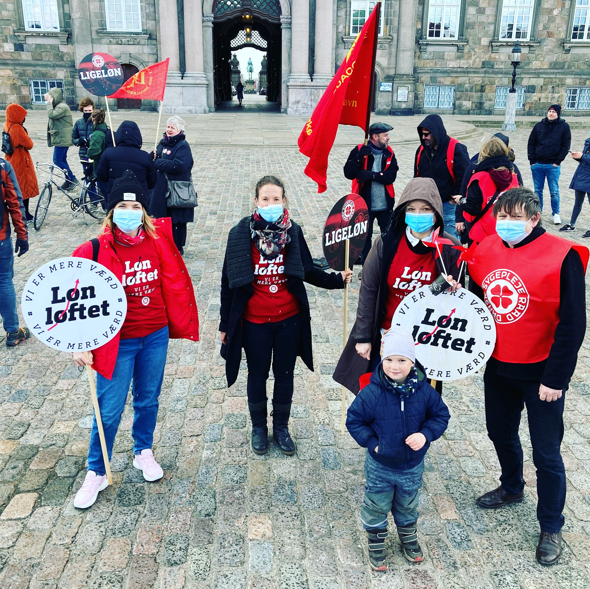 A group of people demonstrating in red clothes and with red banners.