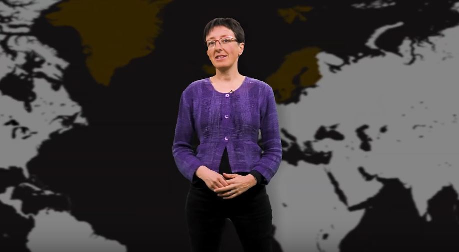 Lady speaking and standing in front of a map of the Nordics